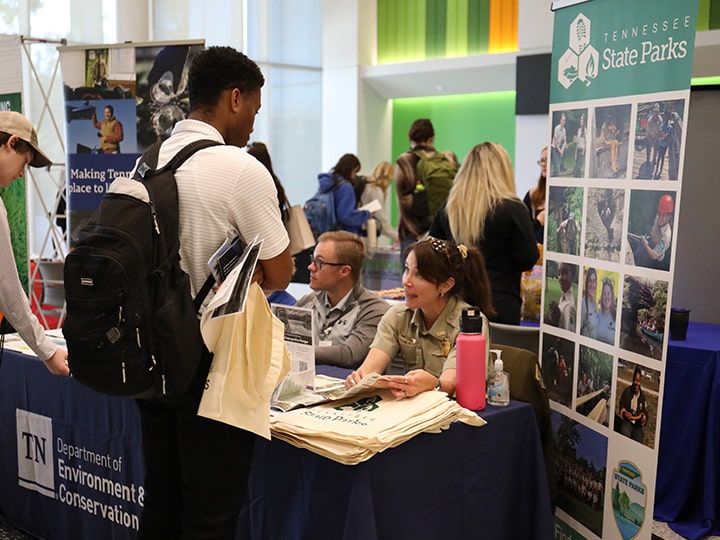 Student at a career fair talking to a Tennessee State Parks professional.