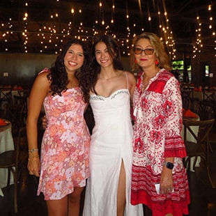 Gracie (far left) with another student and a construction science and management professor at a banquet.