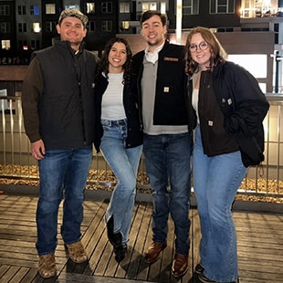 Gracie (center left) with other construction science and management students outside at night.
