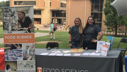 Students of the Food Science Club stand at a booth