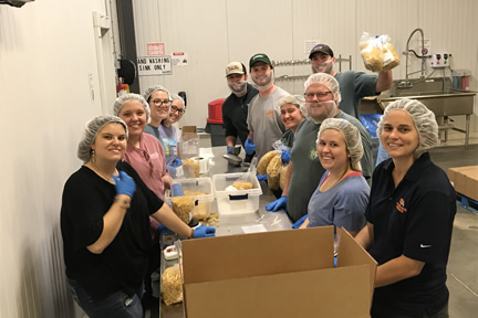 Farm Credit Scholars smile as they package pasta