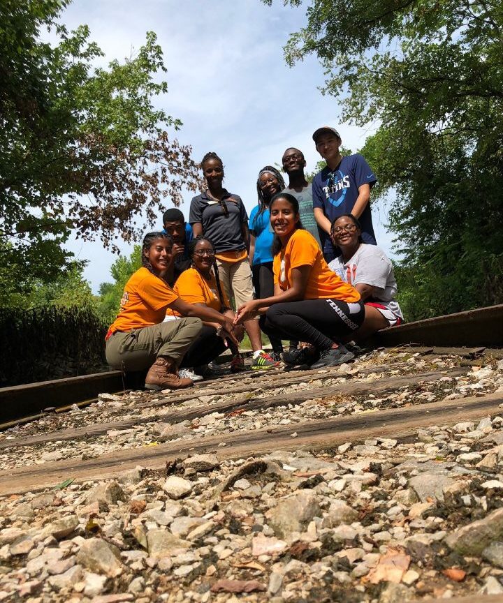 Group of students pose on railroad tracks 