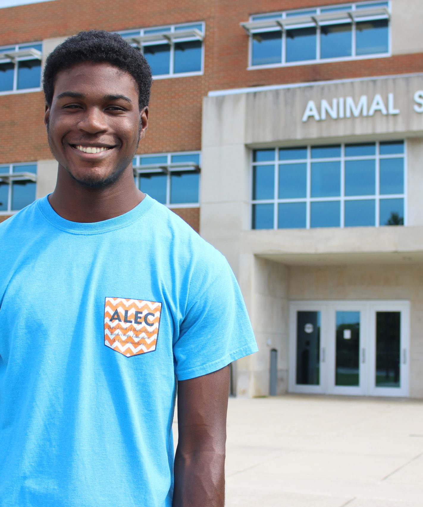 Male student stands in front of the Animal Science Building 