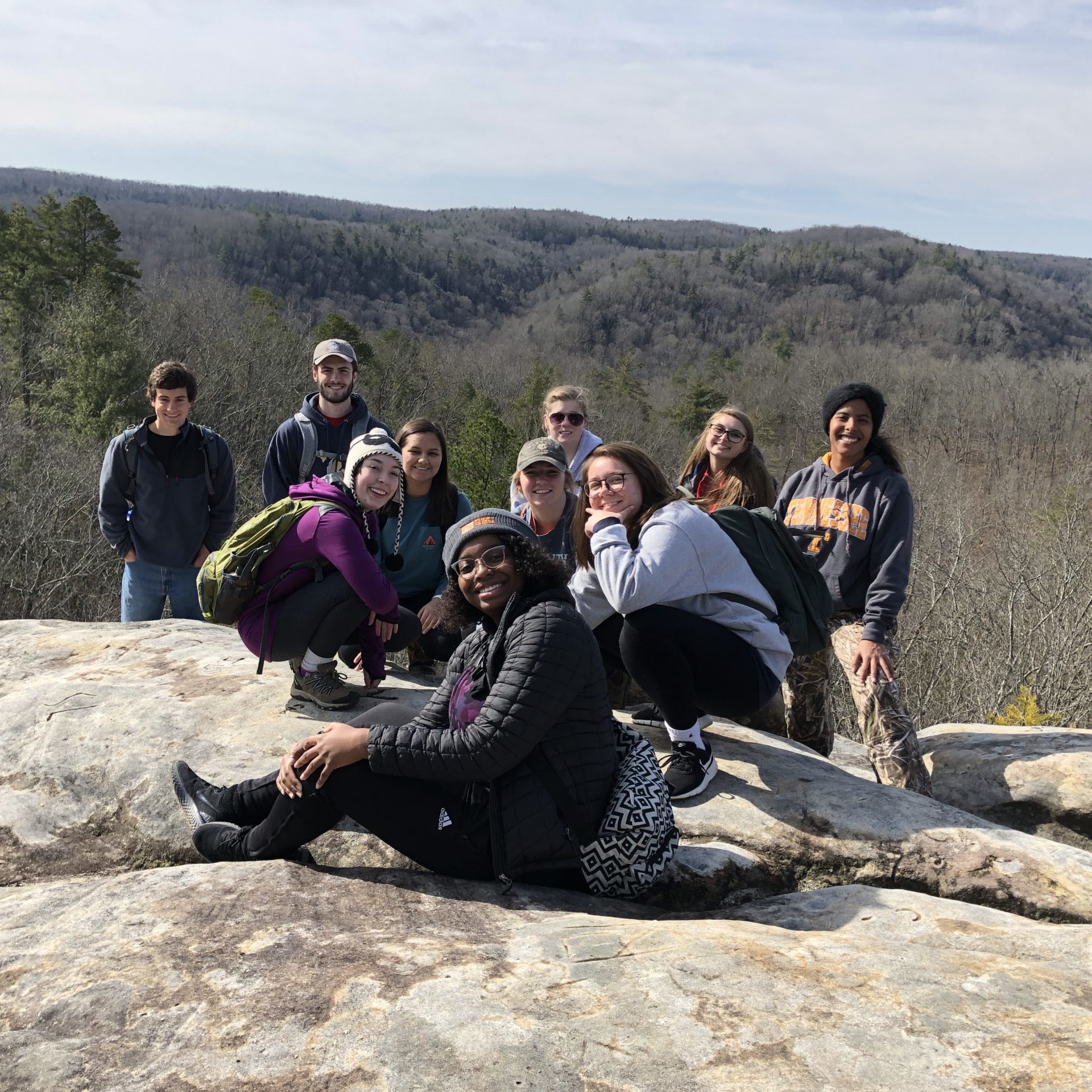 Students pose on a rock 