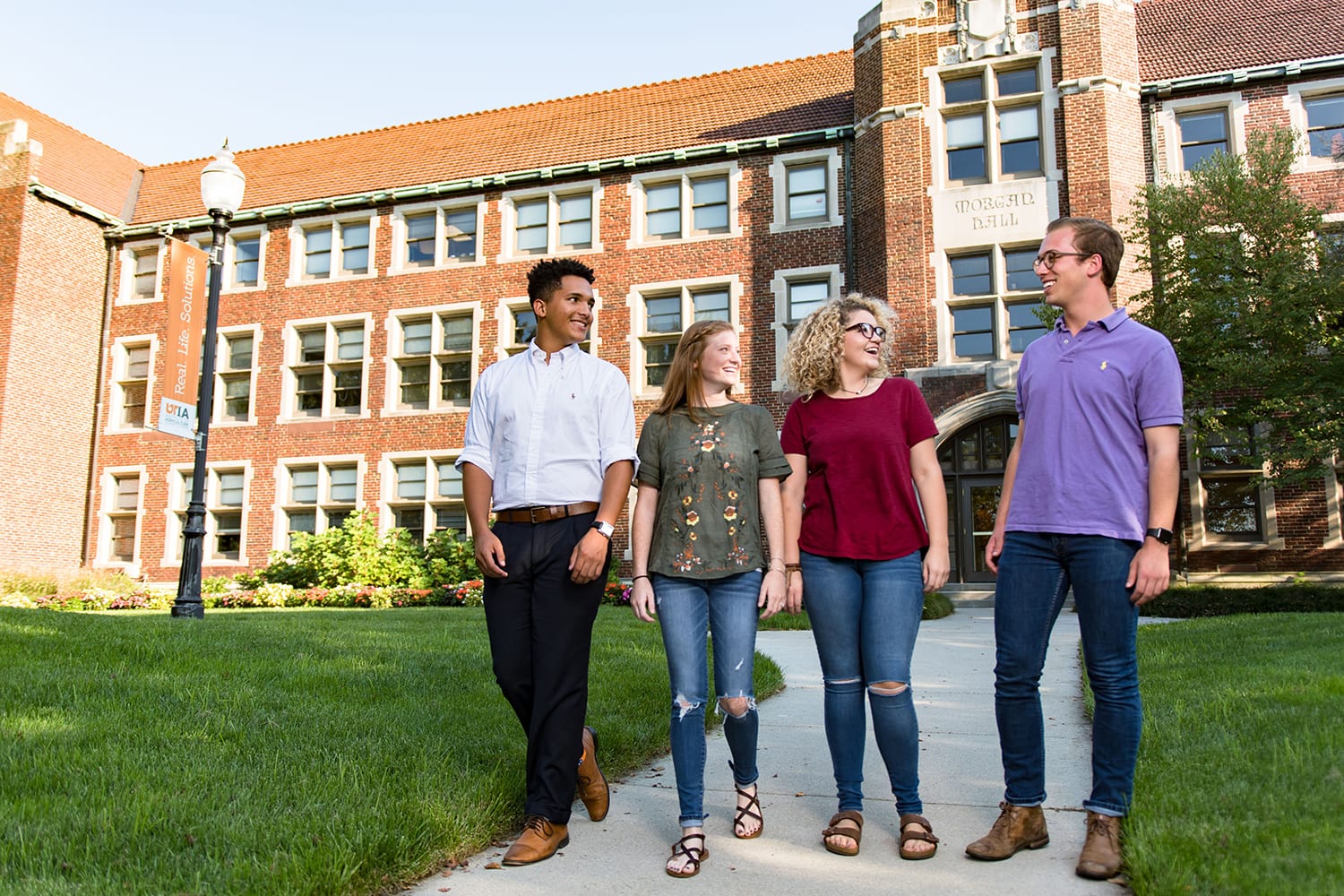Four students from the Department of Agricultural Leadership, Education, and Communications walk together in front of Morgan Hall.