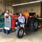 Students standing with a tractor