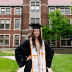 Eilish in cap and gown standing in front of Morgan Hall