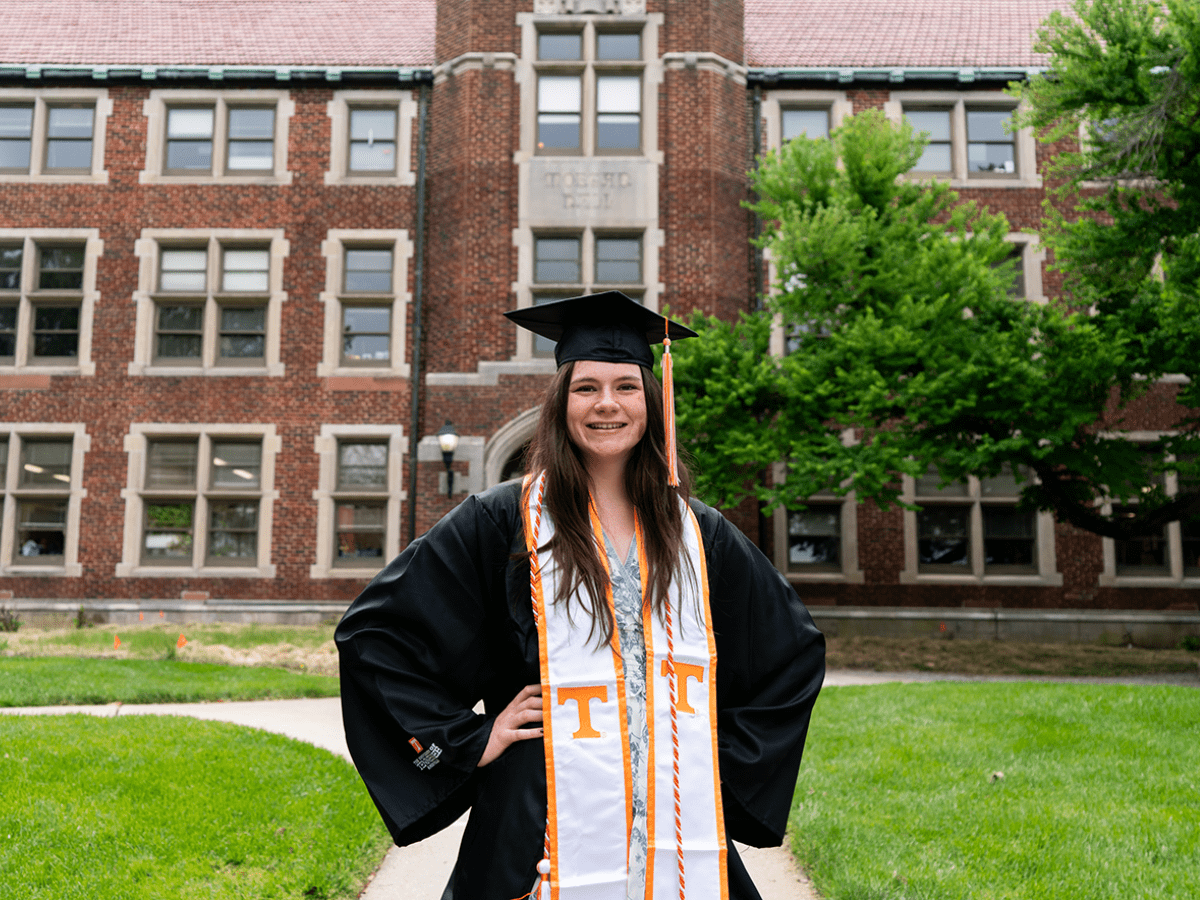 Eilish in cap and gown standing in front of Morgan Hall