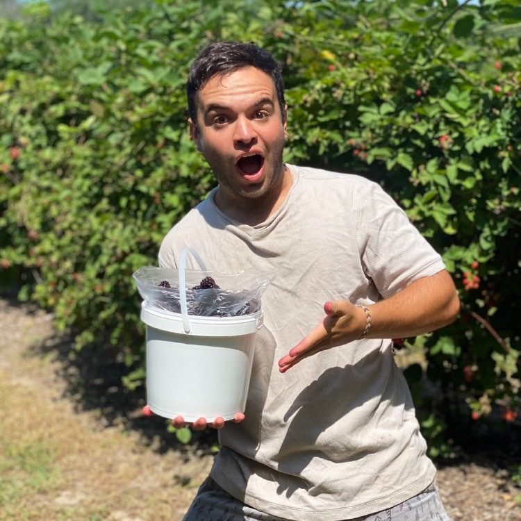 Menachem holding a bucket of berries