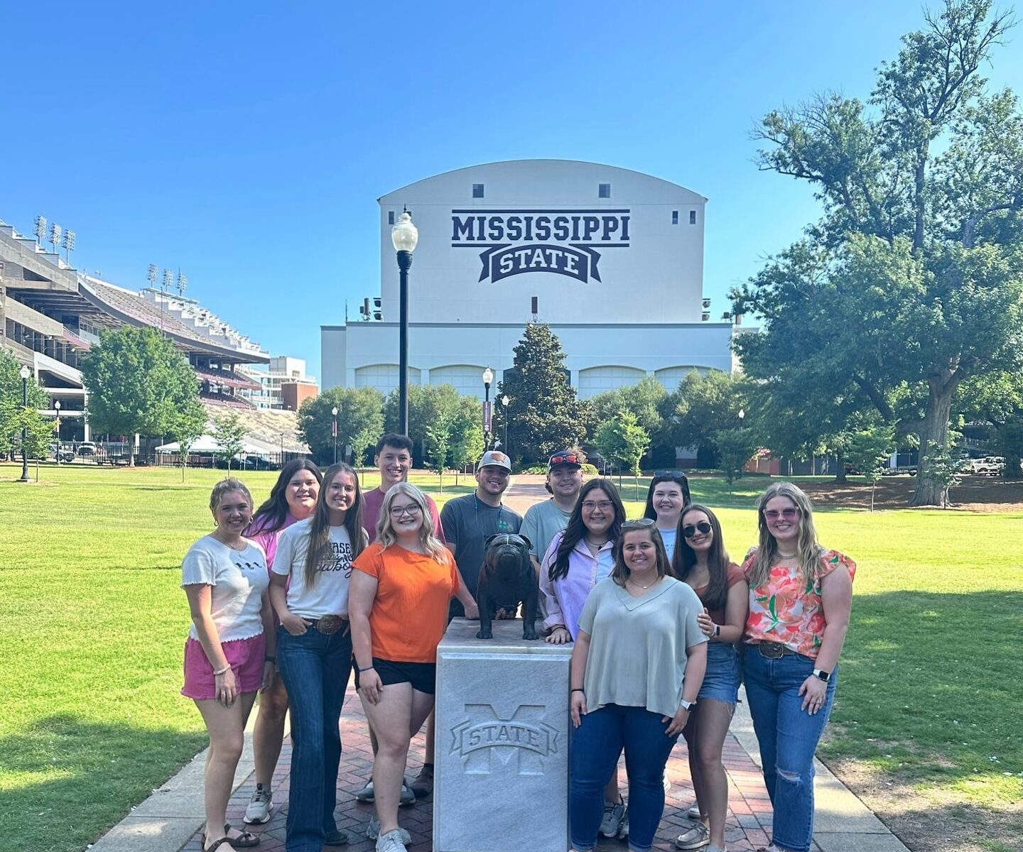 Students standing in front of the Mississippi State bulldog statue