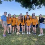 Group photo of Collegiate Farm Bureau, 4-H, and FFA members in an outdoor setting wearing orange shirts